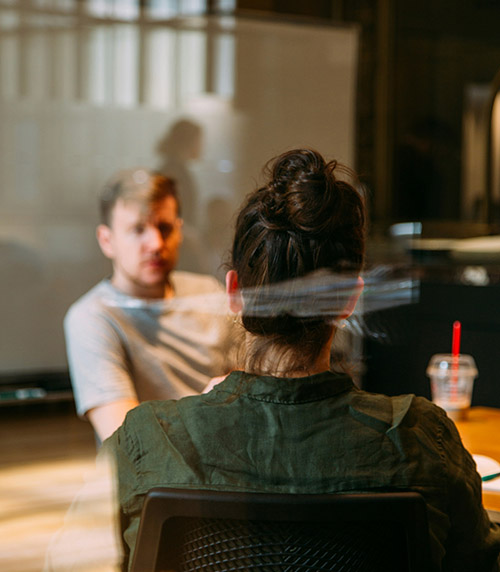 Man and woman talking behind glass